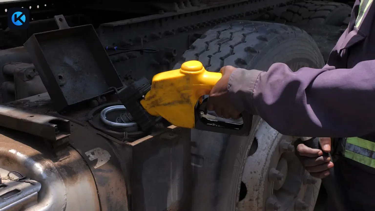 Operator refuelling the diesel tank of a working commercial truck