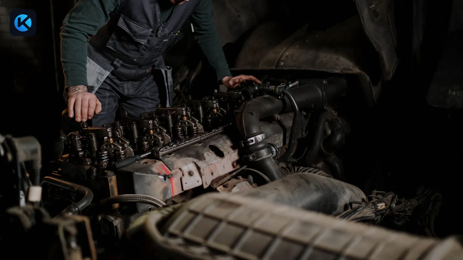 Mechanic inspecting the exposed engine of a commercial truck
